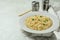 Concept of breakfast with plate of noodles on white textured background