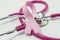Concept of Breast Cancer. Pink ribbon near the pink-purple stethoscope doctor of breast screening, symbolizing the diagnosis, trea