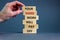 Concept of building success foundation. Men hand put wooden blocks on the stack of wooden blocks. Text `your hard work will pay