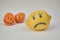 Concept of bullying, discrimination. Group of laughing emoticon faces and one alone look sad and depressed. Lemmons and mandarines