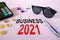Concept: BUSINESS 2021. Calculator, money and glasses