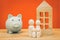 Concept for buying an apartment or building a house, Wooden figurines, Family, cottage, piggy bank, Saving, mortgage, loan and