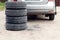 The concept of changing seasonal tires on a car. Folded tires on the background of a car on the street , close-up