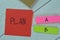 Concept of Choose Plan A to B write on sticky notes isolated on Wooden Table