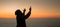 Concept Christian person worship or pray to God. Christian man silhouette with love, faith, devotion to God with sunrise sky