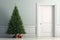The Concept Of Christmas Approaching, With Green Fir Tree Positioned At The Door