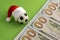 The concept of Christmas football victory or defeat. New Year sports betting or gift. Toy soccer ball in a red Santa Claus hat