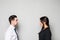 Concept of confrontation in business. Close up photo of two young serious confident people standing face-to-face to each other on