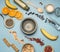 Concept of cooking a healthy breakfast, berries, bananas, oranges, cereals, and milk, a vintage bowl on a blue background flat lay
