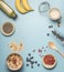 Concept of cooking healthy breakfast, berries, bananas, smoothies, blueberries, oranges, cereals, nutritious bars and milk, framed