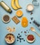 Concept of cooking healthy breakfast, berries, bananas, smoothies, blueberries, oranges, cereals, nutritious bars and milk, a vint