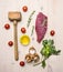 Concept cooking raw beef steak, rosemary, wooden hammer for beating the meat, oil, herbs and spices wooden rustic background to
