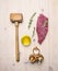 Concept cooking raw beef steak, rosemary, wooden hammer for beating the meat, oil, herbs spices on wooden rustic background to