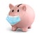 Concept of coronavirus economic crisis. Piggy bank with medical mask
