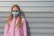 Concept of coronavirus quarantine. Teenager girl in a pigeon mask on the street.
