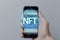 Concept cryptographic NFT. Blockchain network, hand holding smartphone with type of cryptographic non-fungible tokens