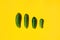 Concept Cucumbers Family on a yellow background. Dad mom baby. Copyspace for designers. Top view