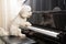 Concept of cute poodle dog playing upright grand piano