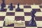 Concept of defeat, fallen king, camera focus on white king chess piece, background blurred. chess board with chess wooden pieces.