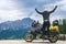 Concept of destination. conquering the top, two hands up, biker man with touring motorcycle on dirt road,