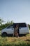 Concept of digital nomad with Caucasian people on romantic journey in minivan. Couple with dogs traveling together on