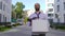 Concept of dismissal from work, recruitment. An employee walks between office buildings with a cardboard box and