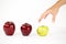 Concept of diversity: a woman`s hand is about to grab the only green apple among the other red ones