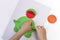 Concept of DIY and children`s creativity. Step by step instruction: how to make applique frog from paper. Step 4 child fingers