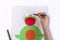 Concept of DIY and children`s creativity. Step by step instruction: how to make applique frog from paper. Step 5 child draws eye