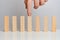 The concept of emphasis on the business process. Hand holds wooden blocks on a white background