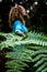 Concept of environment and save the planet earth with close up of tropical green leaf and woman in background - nature and outdoor