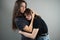 Concept of family support and trust. Mom hugs and comforts teenage daughter on gray background