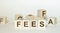 Concept Fees: Wooden cubes with the letters Fees on wooden background