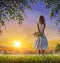 Concept of female loneliness. Acrylic painting lonely girl with bouquet of wildflowers looks into distance at sunset dawn of sun