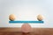 Concept of finding the right balance. Wooden balls on seesaw