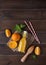 Concept flat lay with fresh squeezed orange juice with mint in bottle with citrus fruits  and paper tube on a brown wooden