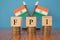 Concept of FPI or foreign portfolio investment on India in wooden block letters on stack of coins with Indian Flag as a