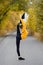 The concept of grace and beauty in gymnastics. View of a girl standing in a vertical twine against the background of an autumn