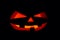 The concept of Halloween. The ghastly, ghastly pumpkin glows wit