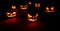 The concept of Halloween. Many glowing fiery light angry scary pumpkins. jack lantern in the dark, on a wooden background