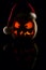 The concept of Halloween and the New Year and Christmas. The evil scary pumpkin Santa in the Santa Claus hat in the dark with ref