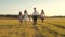 Concept of happy family. Children and mom are playing in meadow. mother and little daughter with sisters walking in park