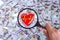 Concept of Health insurance. Red heart in magnifier against the background of Many dollar banknotes