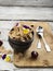 The concept of a healthy breakfast: whole-grain flakes with edible garden flowers, berries in dark ceramic bowls on a