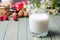 The concept of a healthy diet. Milk in a glass glass Cup on a wooden background. Background-nuts, red apples, raspberries, daisies