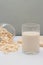 Concept of healthy food, Oat milk in glass and oat flakes or oats cereal poured out of glass jar