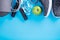 The concept of healthy lifestyle. Sport shoes, bottle of water, apple and yoga mat with copy space on blue background. Exercise eq