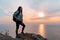 The concept of Hiking and sports recreation. A woman with a backpack on her back poses against the sea and sky. Sunset. Copy space