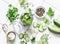 Concept of home canning. Jar of pickled cucumbers and ingredients on a light background, top view