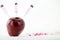 Concept: human GMO manipulation of nature and relative poisoned fruits. Close-up of an apple contaminated with a syringe threaded